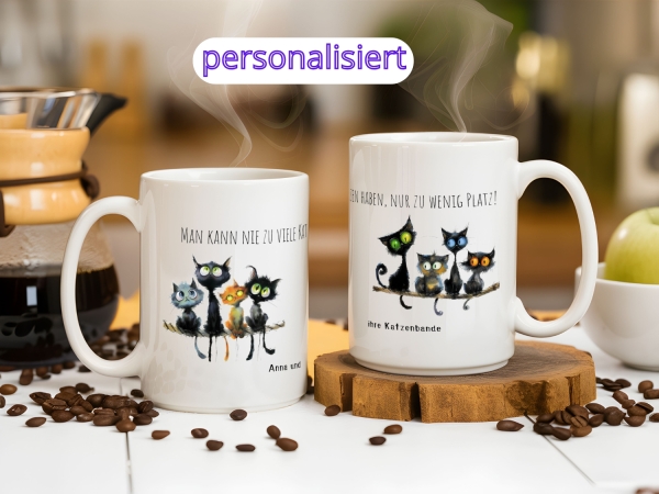 Personalisierte Tassen-Set mit Katzendesign und Sprüchen: eine Tasse zeigt die Aufschrift 'Man kann nie zu viele Katzen haben, nur zu wenig Platz!' mit niedlichen Katzengrafiken und den Namen 'Anna und ihre Katzenbande'. Perfekt für Katzenliebhaber.